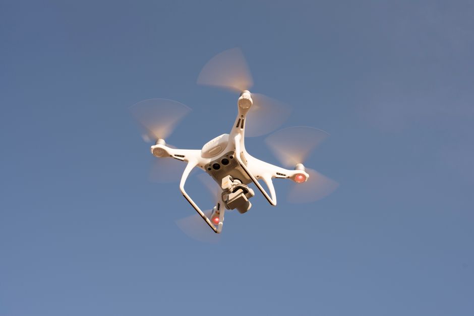 Aerial view of a surveillance drone monitoring a lush rainforest for environmental research.